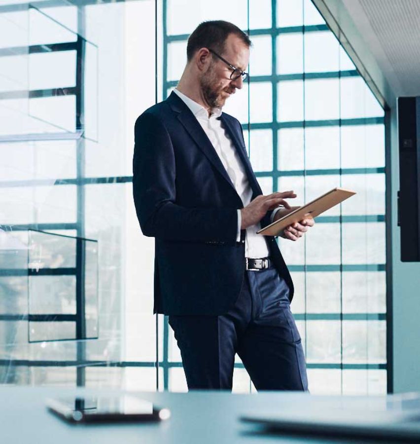 Man in a suit with glasses working on a tablet