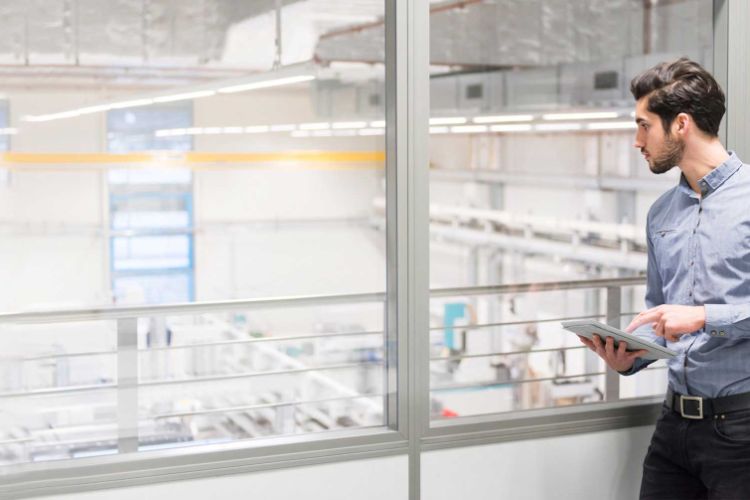 man looking over a manufacturing factory